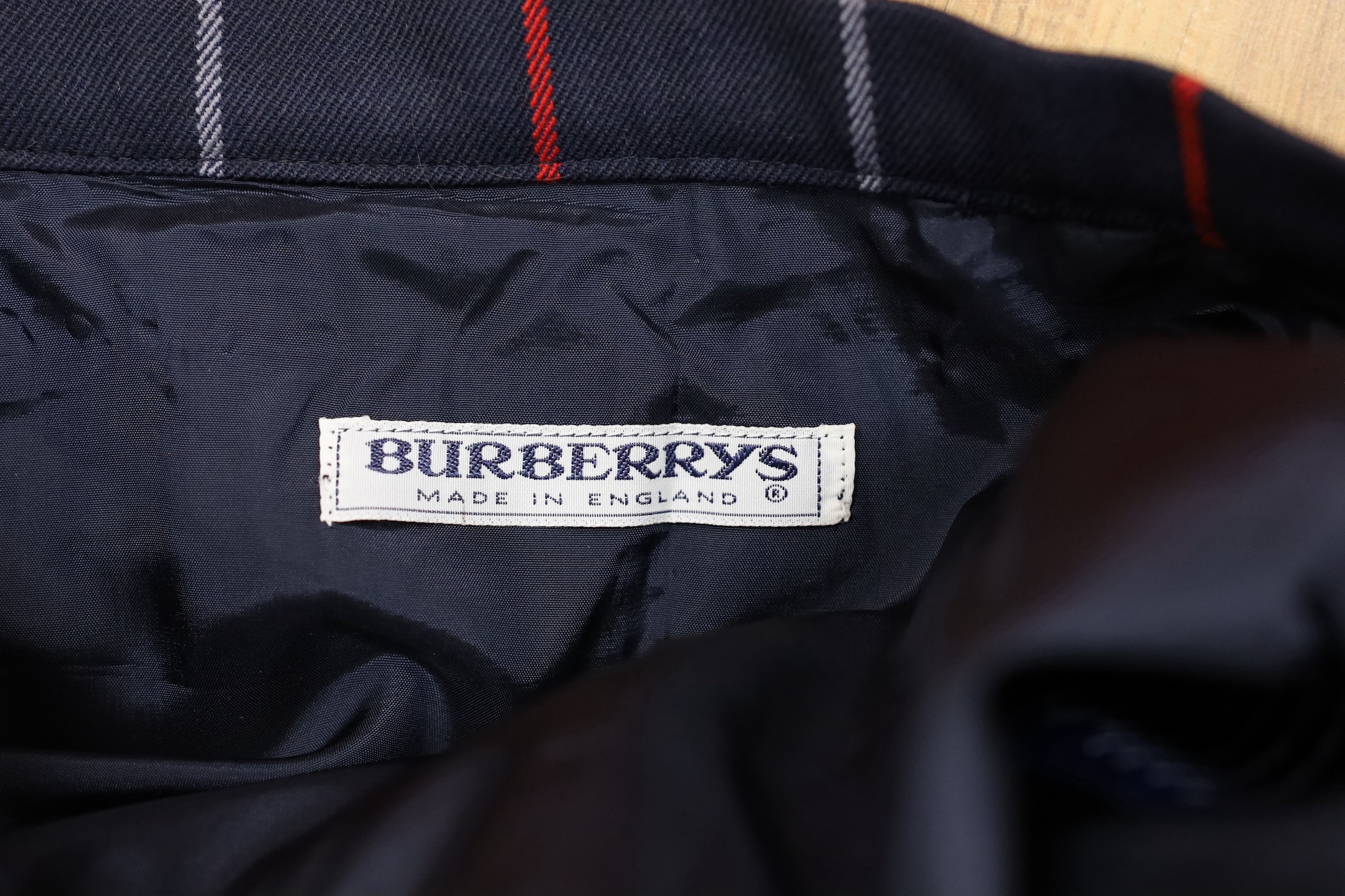 Two vintage Burberry items of clothing: a pleated skirt and a red Harrington jacket